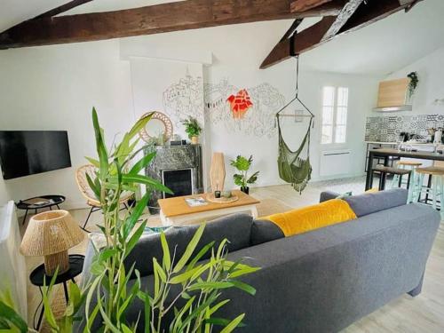 un salon avec un canapé bleu et des plantes dans l'établissement 2 apts communiquants cosy insolites coeur de ville, à Angoulême