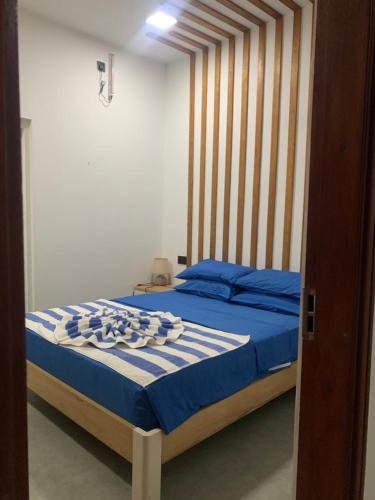 a bedroom with a bed with blue sheets and blue pillows at La Luna Boutique Dhangethi in Dhangethi