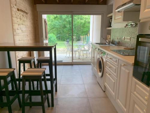 uma cozinha com máquina de lavar e secar roupa em Maison avec jardin privatif Gîte les Chênes de Pastouret, Lussan em Ordonnac