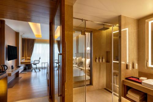 a bathroom with a glass shower and a sink at Grand Madurai by GRT Hotels in Madurai