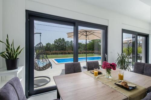 a dining room with a table and a view of a pool at Villa Luna Fiorini in Fiorini