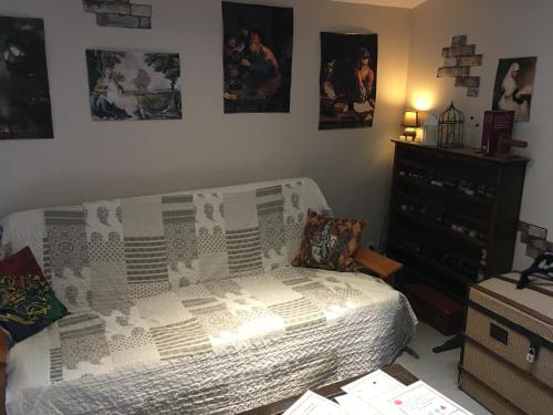 a bedroom with a bed and a dresser and pictures on the wall at Au Rendez-Vous des Sorciers II in Aniane