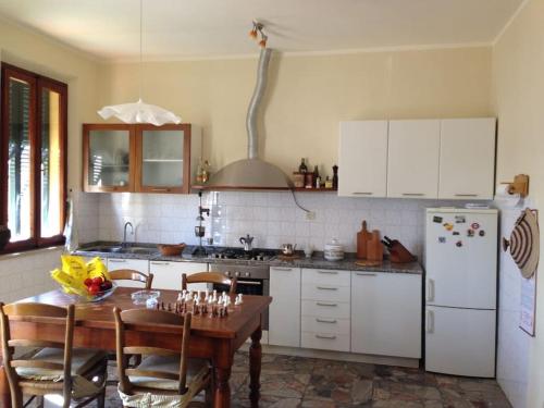 a kitchen with a table and a white refrigerator at L'alloggio del Bon Vivant in Pontedera