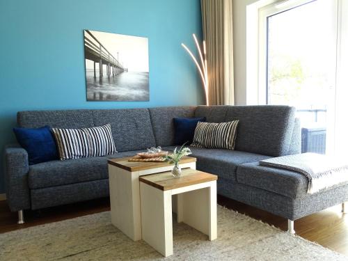 a blue living room with a couch and a table at Gode Wind Quartiere 5 in Dahme