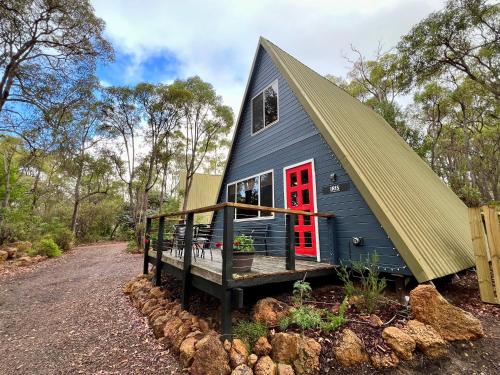 a blue tiny house with a red door at Iris at Porongurup Chalets in Porongurup