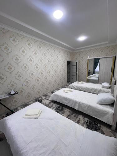 ein Hotelzimmer mit 2 Betten und einem Spiegel in der Unterkunft Apartment 10 минут от Регистана in Samarkand