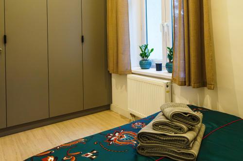 a bedroom with a bed with towels on it at Apartament Pod Szklaną Górką in Sanok
