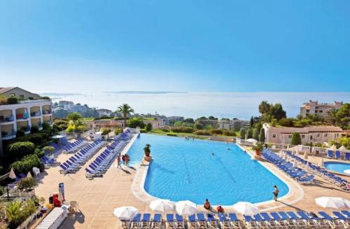 une grande piscine avec des chaises bleues et blanches dans l'établissement Appartement 3P dans Maison Bourgeoise - 6 personnes - Vue Mer - Parking, à Cannes
