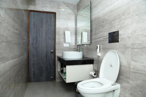 ein Badezimmer mit einem weißen WC und einem Waschbecken in der Unterkunft HOTEL K79 in Jamshedpur