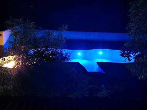 una piscina por la noche con luces azules en Bananchal farms, en Tāla