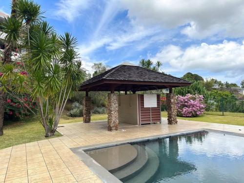 a swimming pool with a gazebo in a yard at FARE Moea - TAHITI in Arue
