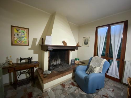 a living room with a fireplace and a blue chair at L'alloggio del Bon Vivant in Pontedera