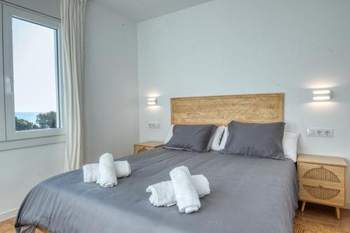 a bedroom with a large bed with white towels on it at Apartamento de lujo con vistas al mar, a dos minutos de la playa in Calella de Palafrugell