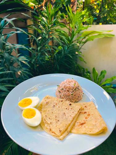 a plate of food with eggs and a cookie on it at La Luna Boutique Dhangethi in Dhangethi