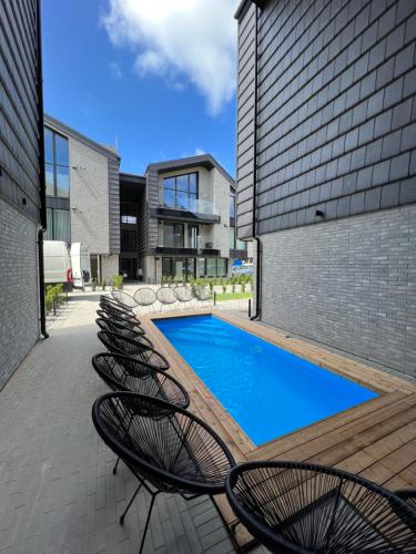 een rij stoelen naast een zwembad bij LightSummerPalanga in Palanga