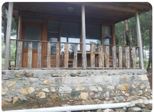 a porch of a house with a stone wall at İda bay bungolow in Edremit