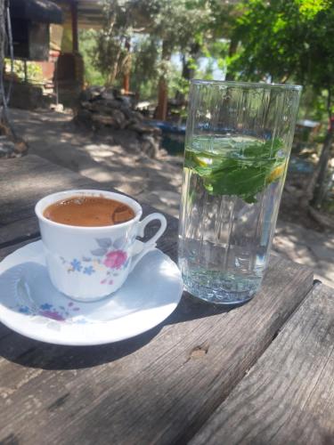 a cup of coffee and a glass of water on a table at İda bay bungolow in Edremit