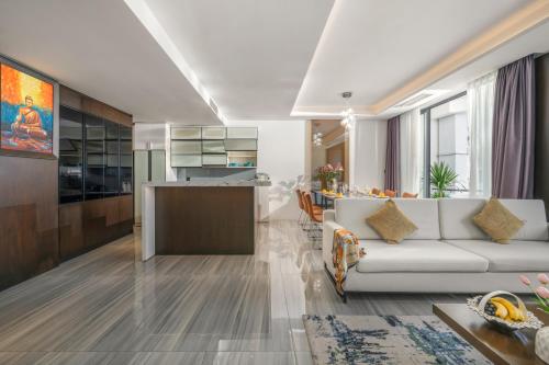 a living room with a white couch and a kitchen at Satya Da Nang Hotel Han Market in Da Nang