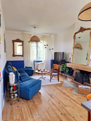 un salon avec un canapé bleu et un miroir dans l'établissement Cœur Toulouse Piscine et Spa, à Toulouse