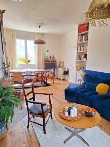 un salon avec un canapé bleu et une table dans l'établissement Cœur Toulouse Piscine et Spa, à Toulouse