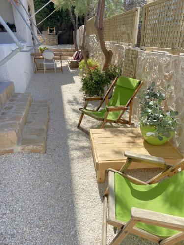 a patio with two chairs and a table and a table and chairs at The Beachhouse Apartments in Vaia