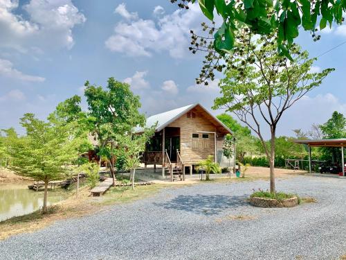 una cabaña de madera con un árbol delante en Rang Robin Farmstay for 4 with pool en Ban Wang Muang