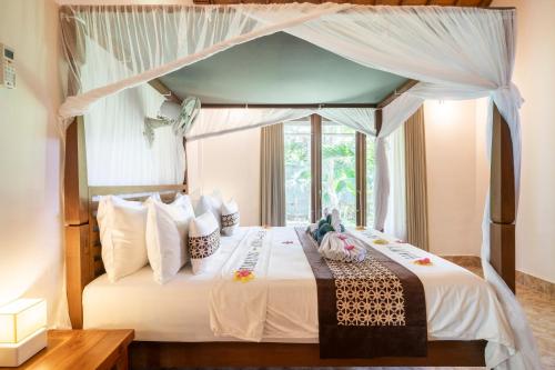 a bedroom with a bed with a canopy at Buntung Beach Villa in Gili Air