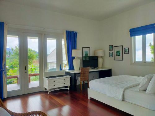 a bedroom with a bed and a desk with a television at Mahesa 1 in Batu