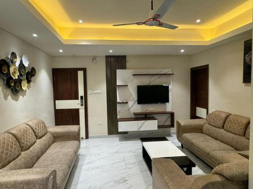uma sala de estar com 2 sofás e uma televisão de ecrã plano em Hotel Asha & Banquet em Bettiah