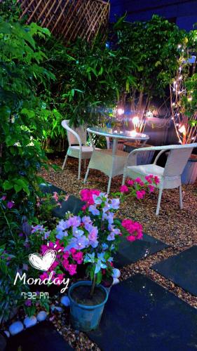 a patio with a table and chairs and flowers at Victorian Elegance Luxury Stays in Amritsar