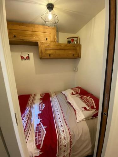une chambre avec un lit dans une petite pièce dans l'établissement Le Gabiott, Appartement neuf pour 4, au pied des pistes à La Rosière, à Montvalezan