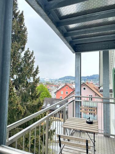 einen Balkon mit einer Bank und Stadtblick in der Unterkunft Stilvolle 2,5 Zimmer Wohnung in St. Gallen