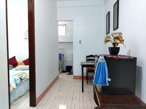 a bedroom with a bed and a table with a blue bag at RM3 - Ground Floor Unit in San Roque Bauan Batangas in Batangas City