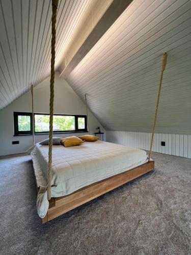sypialnia z łóżkiem huśtawkowym na poddaszu w obiekcie Cottages Family Estate w Kamieńcu Podolskim