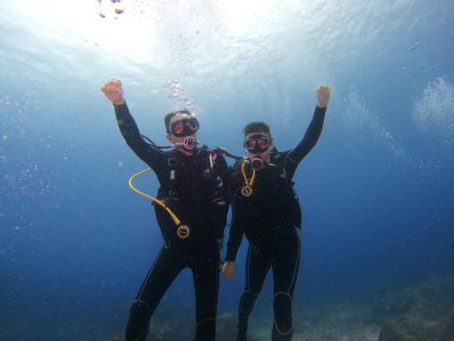 two people standing in the water with their arms up at 綠島海灣會館Bay Resort in Green Island