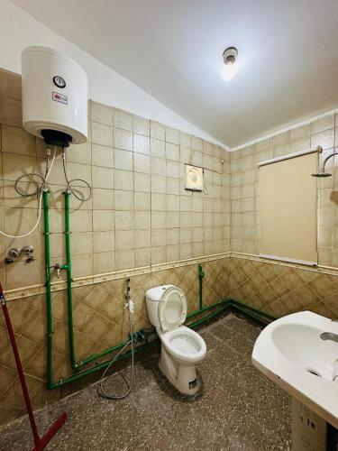 uma casa de banho com um WC e um lavatório em AM a shared room em Doha