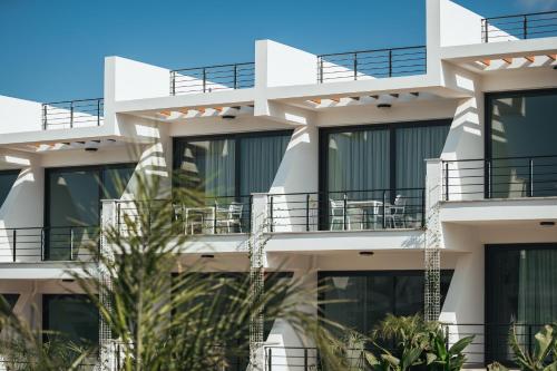 an apartment building with balconies and palm trees at Pearl Island Holiday Homes in Kérynia