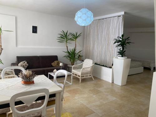 a living room with a couch and a table and chairs at Dimora al Mare in Villanova di Ostuni