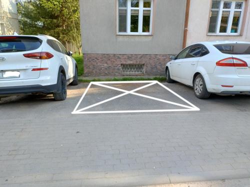 two white cars parked in a parking lot at Nad Łyną in Lidzbark Warmiński