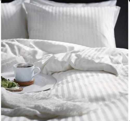 a cup of coffee on a plate on a bed at The Queen Airport Hotel in Arnavutköy