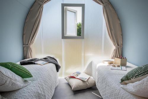 um quarto com 2 camas e um espelho em Camping Larribal em Millau