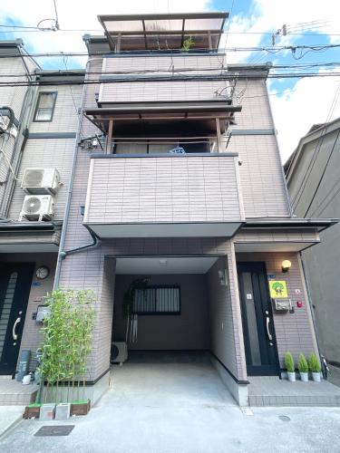 een groot gebouw met een garage en een deur bij WestHouse B 花园町店 in Osaka