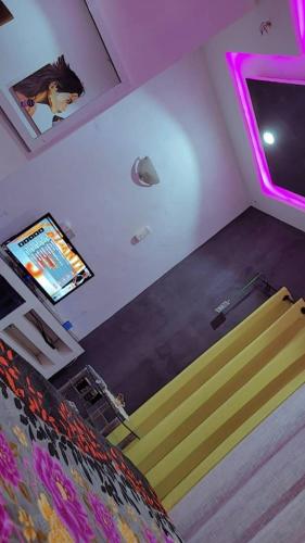 een kamer met een bed, een tv en een trap bij appartementmarcus in Cotonou