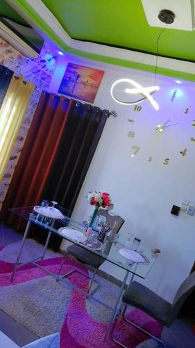 een kamer met een tafel en bloemen aan de muur bij appartementmarcus in Cotonou