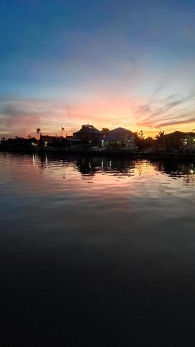 a large body of water with a sunset in the background at ปิดบริการแล้วครับ close in Nonthaburi
