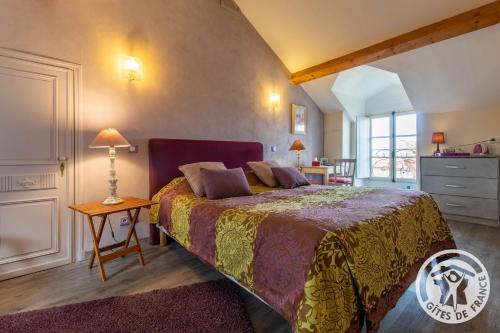 ein Schlafzimmer mit einem großen Bett und einem Tisch in der Unterkunft Manoir d'Orbé in Montreuil-Bellay