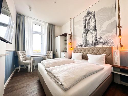 a bedroom with a large bed and a desk at Hotel Rummeni in Borkum