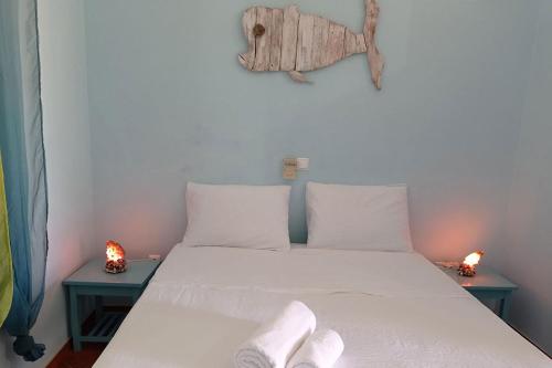 a bedroom with a bed with white sheets and two lamps at Appartamento Percebes. Stella Maris Exclusive in Calheta Do Maio
