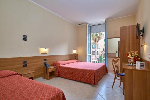 um quarto de hotel com duas camas e uma janela em Hotel Careni Villa Italia em Finale Ligure