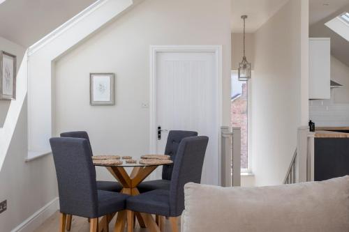 a dining room with a table and blue chairs at The Loft - Rural setting with parking in Bishop Monkton